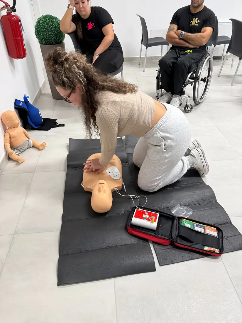Una partecipante esegue la rianimazione cardiopolmonare su un manichino con il defibrillatore didattico